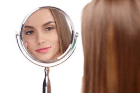 鏡で顔を確認している女性